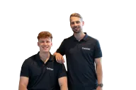 Twee fysiotherapeuten van het FysioNext-team in een FysioNext-poloshirt