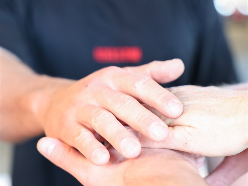 Fysiotherapeut behandelt de hand en pols van een cliënt